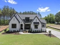 Beautifully landscaped, light colored, single Gathering home, with dark gray accents and a manicured lawn at 2809 Theresa Eileen Way, Raleigh, NC 27603