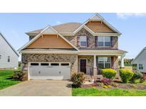 Charming two-story home with brick accents, a two-car garage, and a professionally landscaped front yard at 343 Brinkley Cir, Mebane, NC 27302