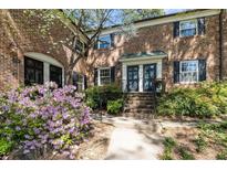 Brick facade townhouse featuring black shutters and lush landscaping at 3743 Yorktown Pl, Raleigh, NC 27609