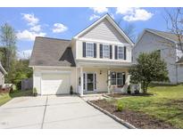 Charming two-story home with a manicured lawn, attached garage, and inviting front porch at 3905 Joe And Ruth Lee Dr, Raleigh, NC 27610