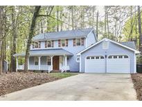 Charming two-story home with blue siding, lovely front porch, shutters, and attached garage at 4 Timberlyne Rd, Chapel Hill, NC 27514