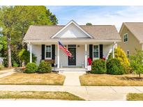 Charming one-story home with white siding, black shutters, and a welcoming front porch with American flag at 524 Beckwith Ave, Clayton, NC 27527