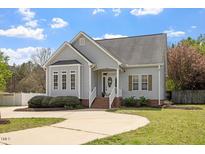 Charming home featuring manicured landscaping, gray siding, and a welcoming front entrance with decorative wreath at 5720 All Clear Ln, Wendell, NC 27591