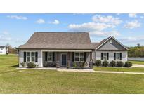 Charming single-story home featuring a welcoming porch, stone-accented posts, and beautiful landscaping at 676 Wall Rd, Wendell, NC 27591