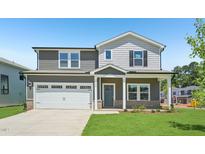 Charming two-story home boasts a landscaped yard, two car garage, and welcoming front porch at 700 Deschutes Dr, Garner, NC 27529