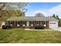 Charming single-story brick home featuring a well-maintained lawn and attached garage at 1208 Briarcliff Rd, Burlington, NC 27215