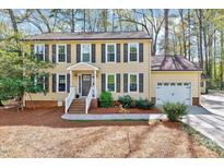 Traditional two-story home with neutral siding, dark shutters, and an attached garage at 1308 Helmsdale Dr, Cary, NC 27511
