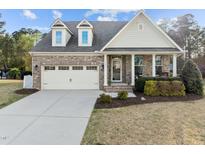 Charming brick home with a two-car garage, front porch, and well-maintained landscaping at 1527 Ingraham Dr, Apex, NC 27502
