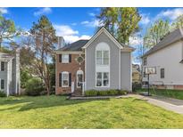 Charming two-story home featuring a brick and gray siding exterior and a well-manicured front lawn at 2340 Florida Ct, Raleigh, NC 27615