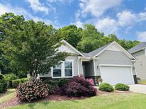 Charming home with gray siding, stone accents, and lush landscaping with blooming flowers at 3037 Willow Ranch Dr, Fuquay Varina, NC 27526