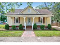 Charming home featuring a welcoming front porch, complemented by neat landscaping and a brick walkway at 309 W Parrish Dr, Benson, NC 27504