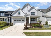 Charming two-story home with a well-manicured lawn and attached garage at 332 Tumbling River Dr, Wendell, NC 27591
