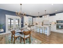 Beautiful kitchen with white cabinetry, an island with barstool seating, stainless appliances, and a dining area at 332 Tumbling River Dr, Wendell, NC 27591
