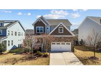 Charming two-story home featuring stone accents, a two-car garage, and a well-maintained front yard at 3927 Chapel Oak Dr, Apex, NC 27502