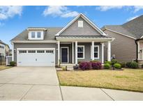 Charming gray home featuring a white garage door and landscaped front yard at 405 Oaks End Dr, Holly Springs, NC 27540