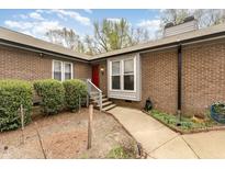 Charming brick home featuring a red front door, concrete walkway, and landscaped yard at 4705 Matt Dr # B, Raleigh, NC 27604
