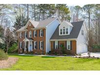 Lovely two-story brick home with attached garage and manicured lawn at 5220 Linksland Dr, Holly Springs, NC 27540