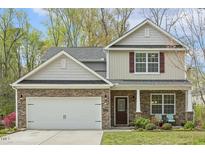 Charming two-story home with stone accents, a two-car garage, and inviting curb appeal at 6021 Watsonia Dr, Zebulon, NC 27597
