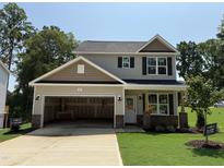 Two-story home with neutral siding, dark shutters, and a two-car garage in a suburban setting at 61 Fetterbush Way, Clayton, NC 27520