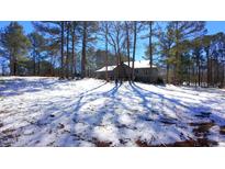 View of home with a wooded lot covered in a blanket of fresh snow at 6509A Fowler Rd, Zebulon, NC 27597