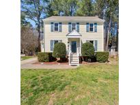 Charming two-story home featuring a well-manicured lawn and inviting curb appeal with blue shutters at 7301 Turtleneck Ct, Raleigh, NC 27616