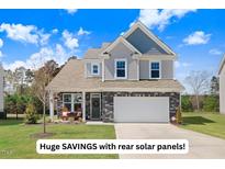 Charming two-story home with stone accents, well-manicured lawn, and an attached two-car garage at 825 Golden Plum Ln, Zebulon, NC 27597