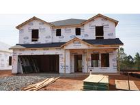 Exterior view of home under construction with Tyvek wrap and windows awaiting installation at 1130 Winding Spring Dr, Mebane, NC 27302