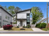 Striking modern home with two stories, eye-catching curb appeal, and manicured landscaping at 1208 Garner Rd, Raleigh, NC 27610