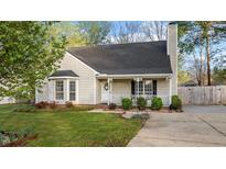 Charming single-story home with a cozy front porch and well-maintained landscaping at 1210 Ventura Springs Ct, Wake Forest, NC 27587