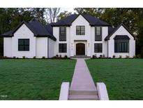 Stunning two-story home with a manicured lawn and a beautiful walkway leading to the front door at 186 Evington Dr, Pittsboro, NC 27312
