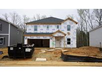 Unfinished two-story home exterior featuring a garage and covered entry with construction materials at 2130 Cherry Creek Rd, Haw River, NC 27258