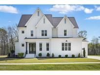 Beautiful two-story white home with well-manicured lawn and inviting front entrance at 216 Meadow Walk Dr, Fuquay Varina, NC 27526
