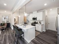 Bright kitchen features a quartz island, pendant lighting, and stainless steel appliances at 237 Shingle Oak Rd, Wake Forest, NC 27587