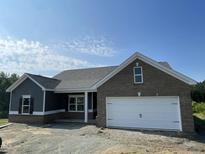 Charming single-story home with a brick facade, attached garage, and professionally landscaped front yard at 249 Spilona Way # 64, Four Oaks, NC 27524