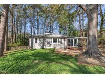 Charming home with a small porch surrounded by lush greenery and mature trees offering a private, serene setting at 3022 Dixon Rd, Durham, NC 27707