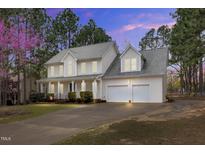Charming two-story home with a two-car garage and well-manicured landscaping at dusk at 384 Rocky Run Ln, Lillington, NC 27546