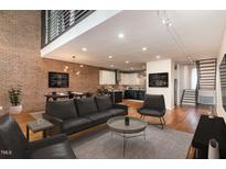 Open concept living room with exposed brick wall and modern furnishings at 4229 American Dr # F, Durham, NC 27705