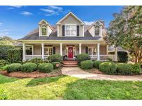 Charming home with a welcoming front porch, manicured landscaping, and a bright red front door at 4303 Thetford Rd, Durham, NC 27707