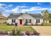 Charming single-story home with a bright red front door, solar panels and well-maintained landscaping at 503 N Sellers St, Selma, NC 27576