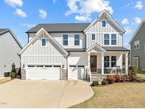 Charming two-story home featuring a gray and white color scheme, well-manicured lawn, and inviting front porch at 508 Moore Hill Way, Holly Springs, NC 27540