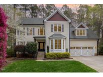 Charming two-story home featuring a landscaped yard, attached two-car garage, and classic architectural details at 812 Oxgate Cir, Raleigh, NC 27615