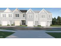Charming townhome showcases a light blue exterior, complemented by a private garage for convenient parking and additional storage at 812 Windmill Palm Dr, Zebulon, NC 27597