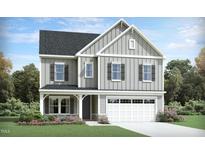Charming two-story home featuring a two-car garage, landscaped front yard, and stylish board and batten siding at 929 Thimbleweed Way, Wake Forest, NC 27587