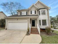 Charming two-story home featuring a garage and well-manicured lawn and a brick stairway to the front door at 100 Ampad Ct, Cary, NC 27513
