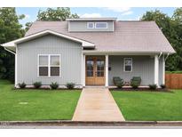Charming home with a well-maintained front yard, covered porch, and natural wood front door at 1008 North St, Durham, NC 27701
