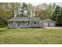 Charming single-story home with a welcoming front porch, detached two-car garage, and well-manicured lawn at 114 Marshay Meadow Rd, Youngsville, NC 27596