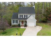 Charming two-story home with a well-manicured lawn, mature trees, and a welcoming front porch at 122 Waterfall Ct, Cary, NC 27513