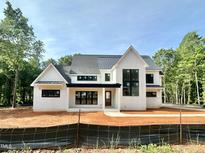 Stunning new construction home with modern black trim, board and batten siding, and a metal roof at 1309 Sanctuary Pond Dr, Raleigh, NC 27603