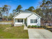 Charming single-story home with white siding, black shutters, and a well-manicured front yard at 1406 Summerville Mamers Rd, Lillington, NC 27546
