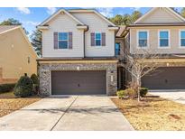 Charming townhome with a brick and siding exterior, two-car garage, and well-maintained landscaping at 154 Alamosa Pl, Cary, NC 27519